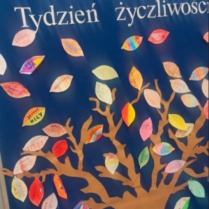Zdjęcie przedstawia z bliska tablicę z drzewem życzliwości, na którym umieszczone są listki z miłymi słowami. 
