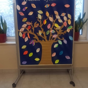 Zdjęcie przedstawia tablicę z drzewem życzliwości, na którym umieszczone są listki z miłymi słowami oraz napis 21-25 listopada Tydzień życzliwości.