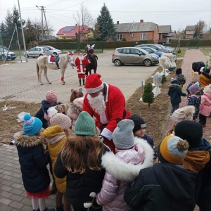 Mikołaj rozdaje wszystkim dzieciom prezenty.