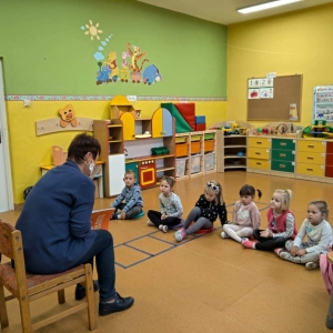 Zdjęcie przedstawia nauczyciela-bibliotekarza czytającego bajki dzieciom z przedszkola w ramach obchodów Miesiąca Bibliotek Szkolnych