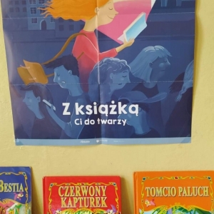 Zdjęcie przedstawia wystawkę biblioteczną: plakat związany z  obchodami Międzynarodowego Miesiąca Bibliotek Szkolnych oraz książki z ulubionymi bajkami dzieci